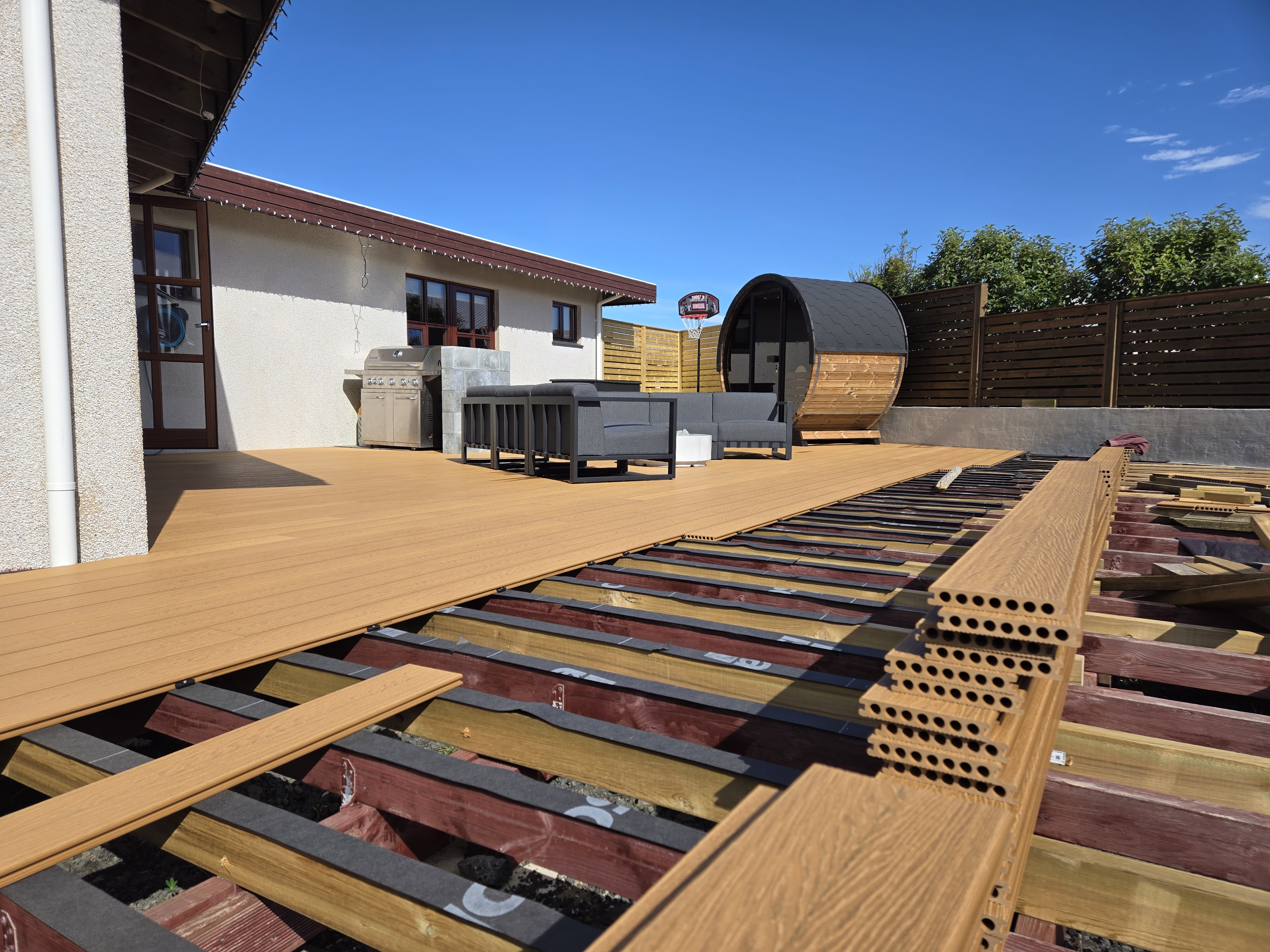 Teak-lituð WPC pallaefni í uppsetningarferli með útihúsgögnum